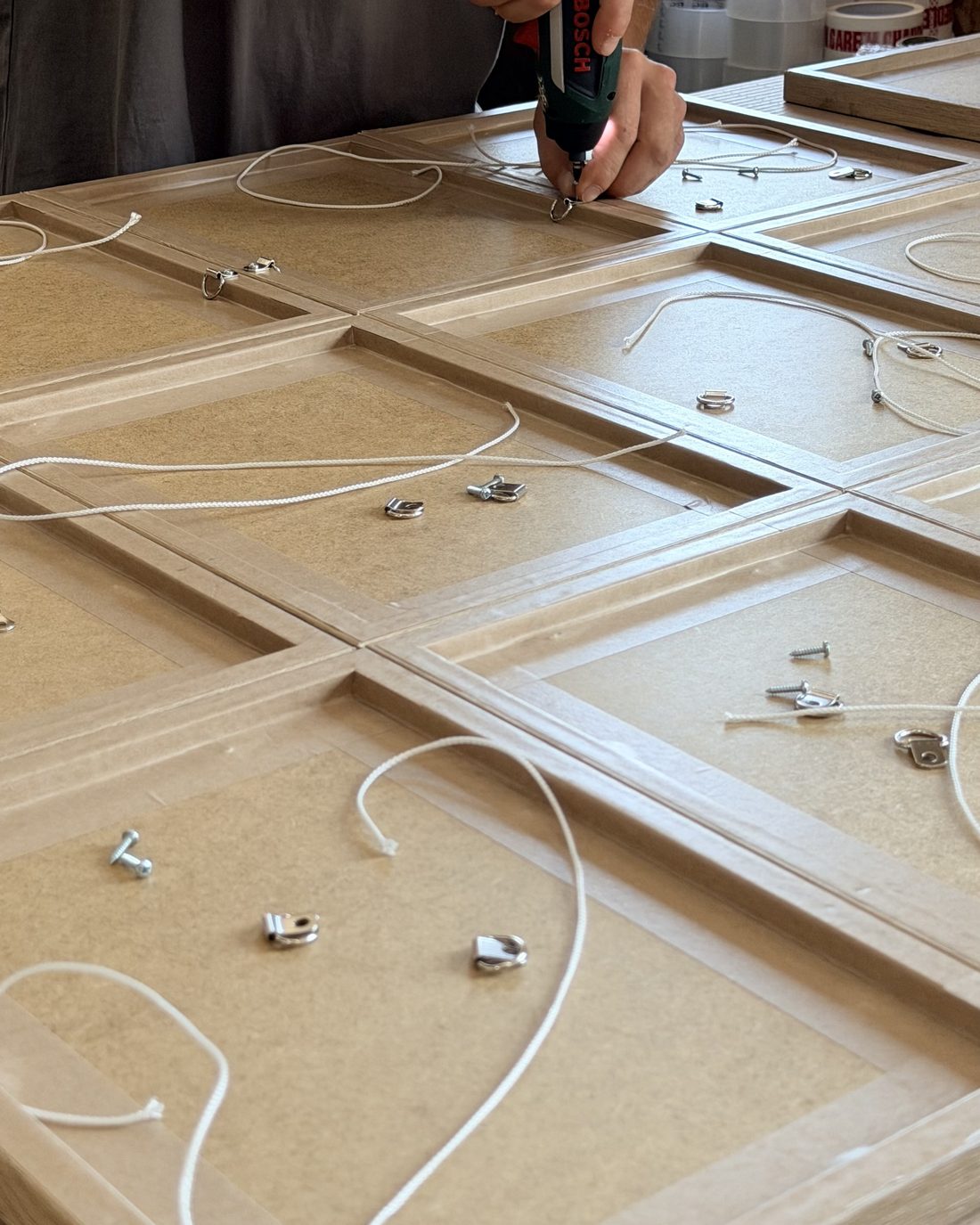 Hanging cord and D rings being fitted to the backs of handmade picture frames